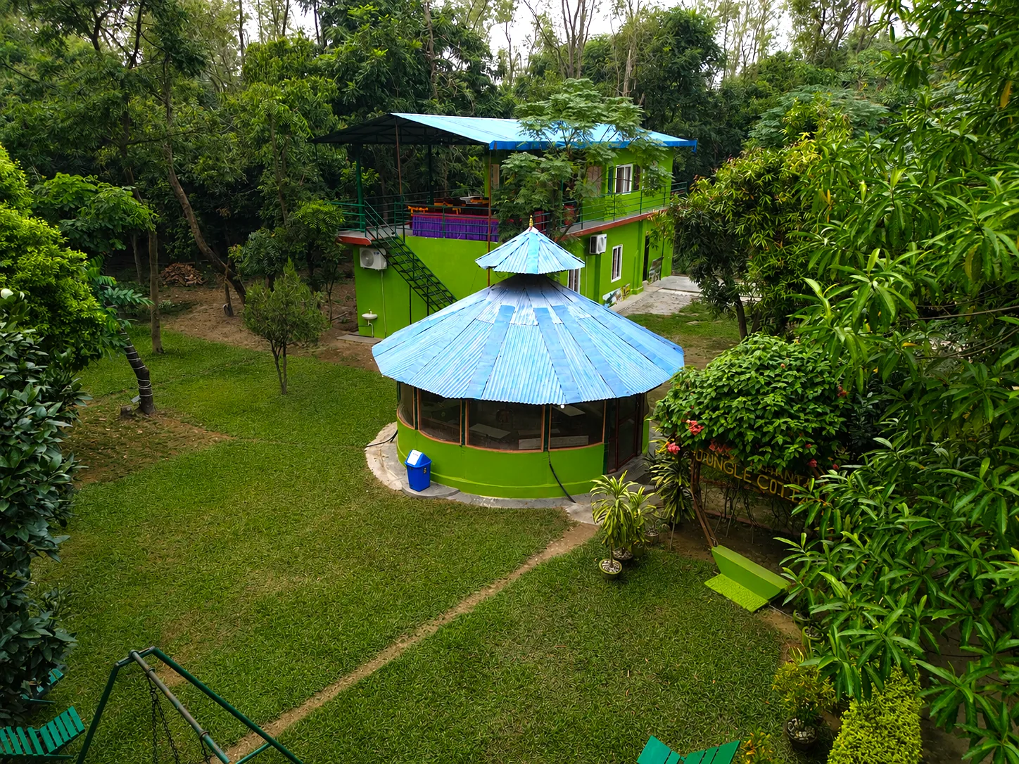 Aerial view of Shuklaphanta Jungle Cottage — round restaurant and green cottage blocks in jungle gardens