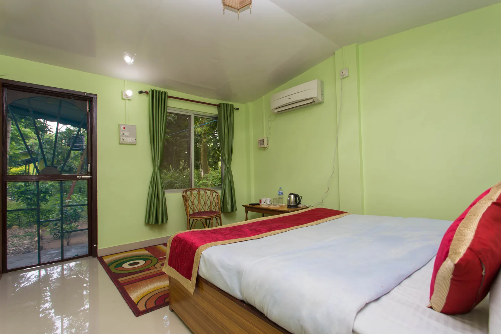 Master bedroom at Shuklaphanta Jungle Cottage with private garden door and jungle-facing window