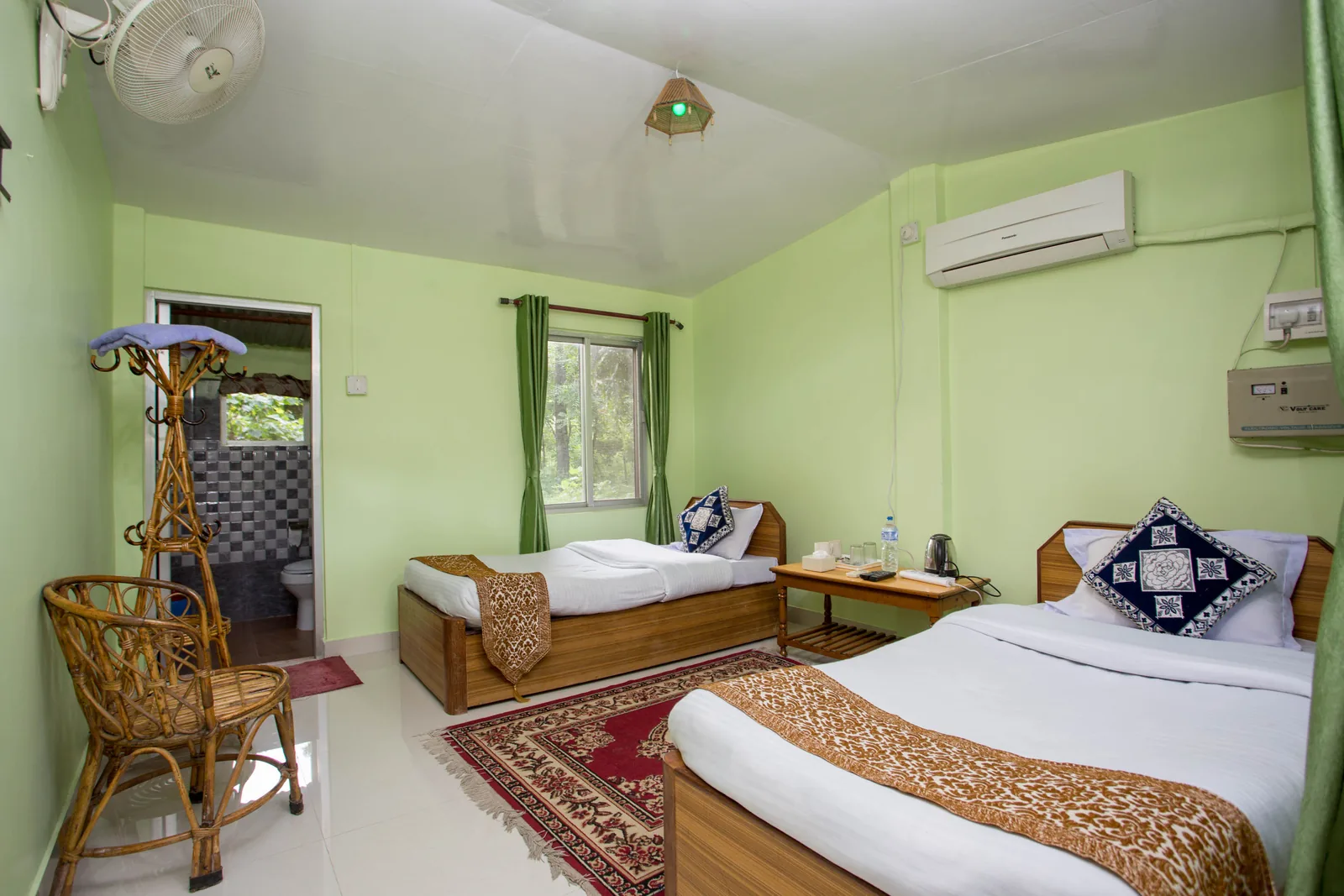 Twin Single Room at Shuklaphanta Jungle Cottage — beds, seating and private bathroom